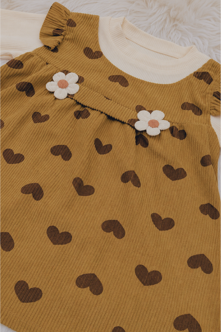 Close-up of mustard heart print cotton interlock fabric used in Featherhead Girls Corduroy Style Frock FG-5623
