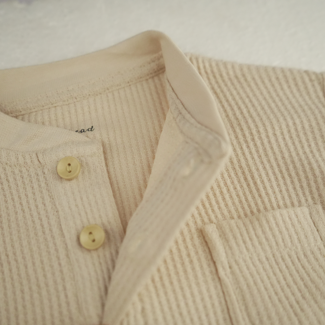 Close-up of almond peach waffle thermal baby top with button details FN-6519.